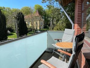 a balcony with a table and chairs and a house at Ferienwohnung Föhrmieten in Wyk auf Föhr