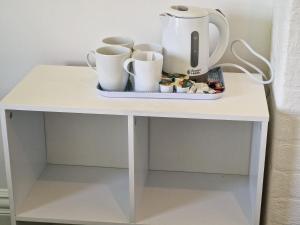 a white table with cups and a tea pot on it at Number 40 in Blackpool