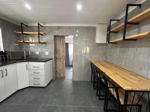 Una cocina con gabinetes blancos y una mesa de madera. en Villa da Lucia, en St Lucia