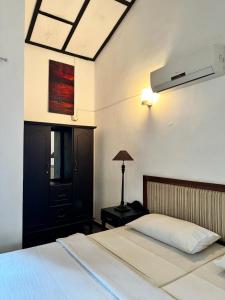 um quarto com uma cama e um candeeiro sobre uma mesa em Moonbeam Kandy em Kandy