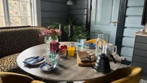 una mesa de comedor con una mesa redonda con platos y vasos en Ladegaarden, en Skien