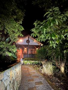 une maison éclairée la nuit dans l'établissement Cottage In The Woods - Formerly King Ludwigs Cottage, à Maleny