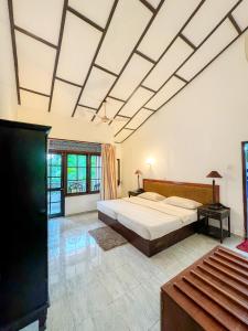 um quarto grande com uma cama grande e uma televisão em Moonbeam Kandy em Kandy