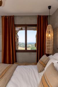 ein Schlafzimmer mit einem Bett und einem großen Fenster in der Unterkunft U MULINU CASANELLI in Fozzano