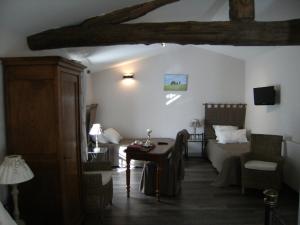 a living room with a bed and a table in a room at Domaine du Fief aux Dames in Monnières
