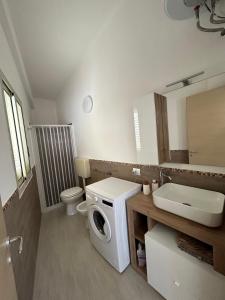 een badkamer met een wasmachine en een wastafel bij La terrazza della Dolce Casa - Blue Wave - Casuzze in Villaggio Azzurro