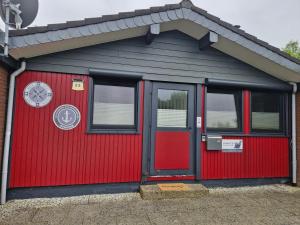 布特亚丁根Bungalow Loos的门上有钟的红色车库