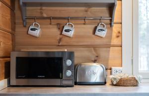een keuken met een magnetron, een broodrooster, een broodrooster en tassen bij Arctic Nature Lodge in Inari
