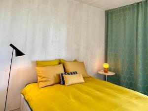 een slaapkamer met een geel bed en een lamp bij Chalet contemporain in Gryon +24 foto's