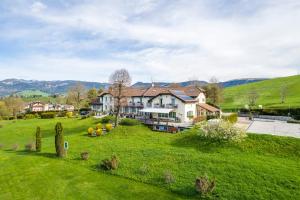 a large house on a green hill with a yard at Villa Bonomo Charme Hotel in Asiago