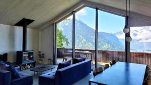 a living room with a large window with a view of mountains at Chalet contemporain in Gryon