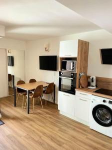 eine Küche mit Tisch und ein Esszimmer in der Unterkunft Duplex T3 avec jardin, bord de mer et parking in Six-Fours-les-Plages
