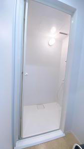 a shower with a glass door in a bathroom at ゲストハウスあさひのお宿 in Kurodahara