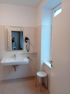 a bathroom with a sink and a phone on the wall at Adlerhof in Salzburg