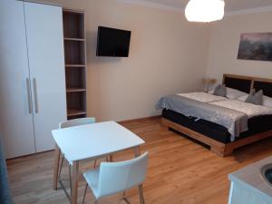 1 dormitorio con 1 cama, mesa y sillas en Adlerhof en Salzburgo