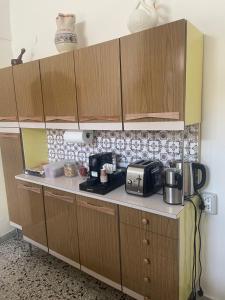 una cucina con armadi in legno, tostapane e forno a microonde di La Casa di Nonna Lina a Ordona
