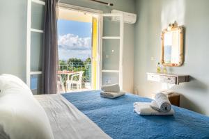 a bedroom with a bed and a view of a balcony at Anastasia Studios Katelios in Katelios