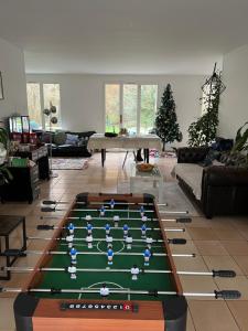 a living room with a pool table in the middle at Location proche de Paris, Versailles et de la nature in Plaisir