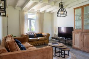 a living room with a couch and a tv at Vakantiehuis Braembeyerhoek in Bruges