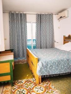 een slaapkamer met een bed en een raam bij Maison Albatros in Mahdia