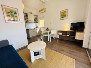 a living room with a table and a tv at Boomerang Apartments in Klek