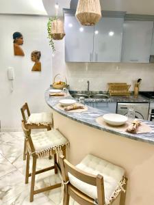 a kitchen with a counter with two chairs and a sink at Casa Lulu cabo verde in Praia