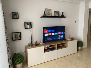 ein Wohnzimmer mit einem Fernseher auf einem weißen Schrank in der Unterkunft Precioso apartamento con vistas al mar in Benicàssim
