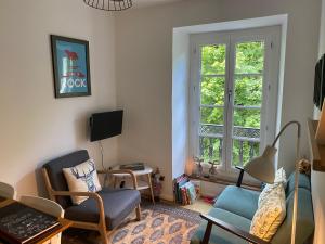 sala de estar con 2 sillas y ventana en AU 47 ALLÉES D'ETIGNY - CENTRAL & STANDING - avec parking, linge de lit et de toilette inclus en Luchon