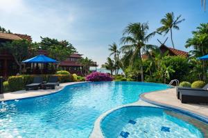 uma piscina num resort com cadeiras e guarda-sóis em Beachfront Villa, Bang Po em Ban Bang Po