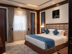 Un dormitorio con una cama grande y una ventana en Innyar Hotel - فندق انيار en Riad