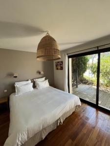 sypialnia z dużym białym łóżkiem i dużym oknem w obiekcie Villa Mané Lann Maison d'hôtes & spa w mieście Carnac