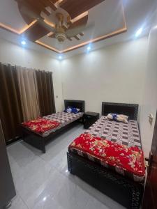 2 aparte bedden in een kamer met een plafond bij Shah Guest House in Jhelum