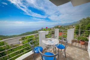 a balcony with a table and chairs and a view of the ocean at Eduard Lagji Apartament in Lukovë