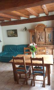 ein Wohnzimmer mit einem Holztisch und einer grünen Couch in der Unterkunft Oustals De Lavail in Ascou