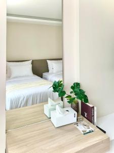 een slaapkamer met 2 bedden en een tafel met een spiegel bij สุขใจแกรนด์ in Loei