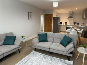 a living room with two couches and a kitchen at Spacious, bright, modern flat in Brentwood
