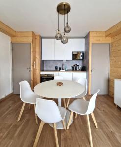 a kitchen and dining room with a white table and chairs at LeChalet N22 Au pied des pistes in Saint-Lary-Soulan