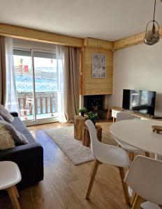 een woonkamer met een bank en een tafel met stoelen bij LeChalet N22 Au pied des pistes in Saint-Lary-Soulan