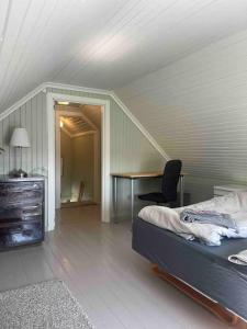 een slaapkamer met een bed, een bureau en een stoel bij Koselig hus med 4 soverom 7 min gange fra sentrum in Gjøvik
