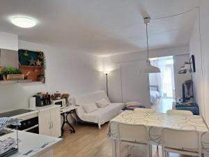 una sala de estar blanca con mesa y sillas en CostaBrava Colera Apartament, en Colera