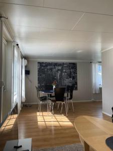 een woonkamer met een eettafel en stoelen bij Koselig hus med 4 soverom 7 min gange fra sentrum in Gjøvik