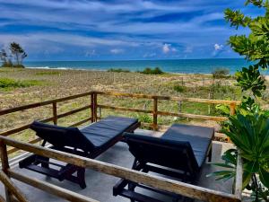 eine Terrasse mit zwei Stühlen und der Strand in der Unterkunft Whisky Point Surf Cabana in Arugam Bay