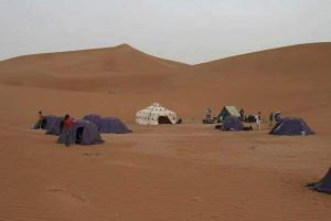 a group of tents in the middle of a desert at Mhamid Tours berbère in Mhamid