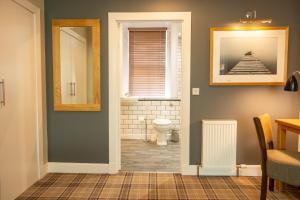ein Bad mit einem WC, einem Fenster und einem Spiegel in der Unterkunft Glen Mhor Hotel in Inverness
