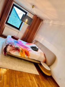 a bedroom with a bed with a colorful comforter and a window at Maison avec jardin, 3 chambres in Clavier +5 photos