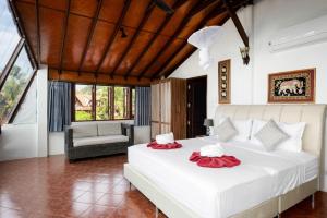 1 dormitorio con 1 cama blanca grande y 1 silla en Beachfront Villa, Bang Po en Ban Bang Po