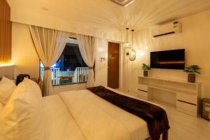 a bedroom with a large bed and a television at Serene Oasis Resort - Oslob Cebu Philippines in Oslob +39 photos