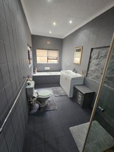 a bathroom with a toilet and a sink and a shower at Mosselbay Dream Home in Mossel Bay