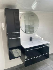 a bathroom with a sink and a mirror at Maison proche de la Mer ! in Grues