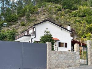 uma casa branca com uma cerca à frente. em Casa dos Avós em Gerês